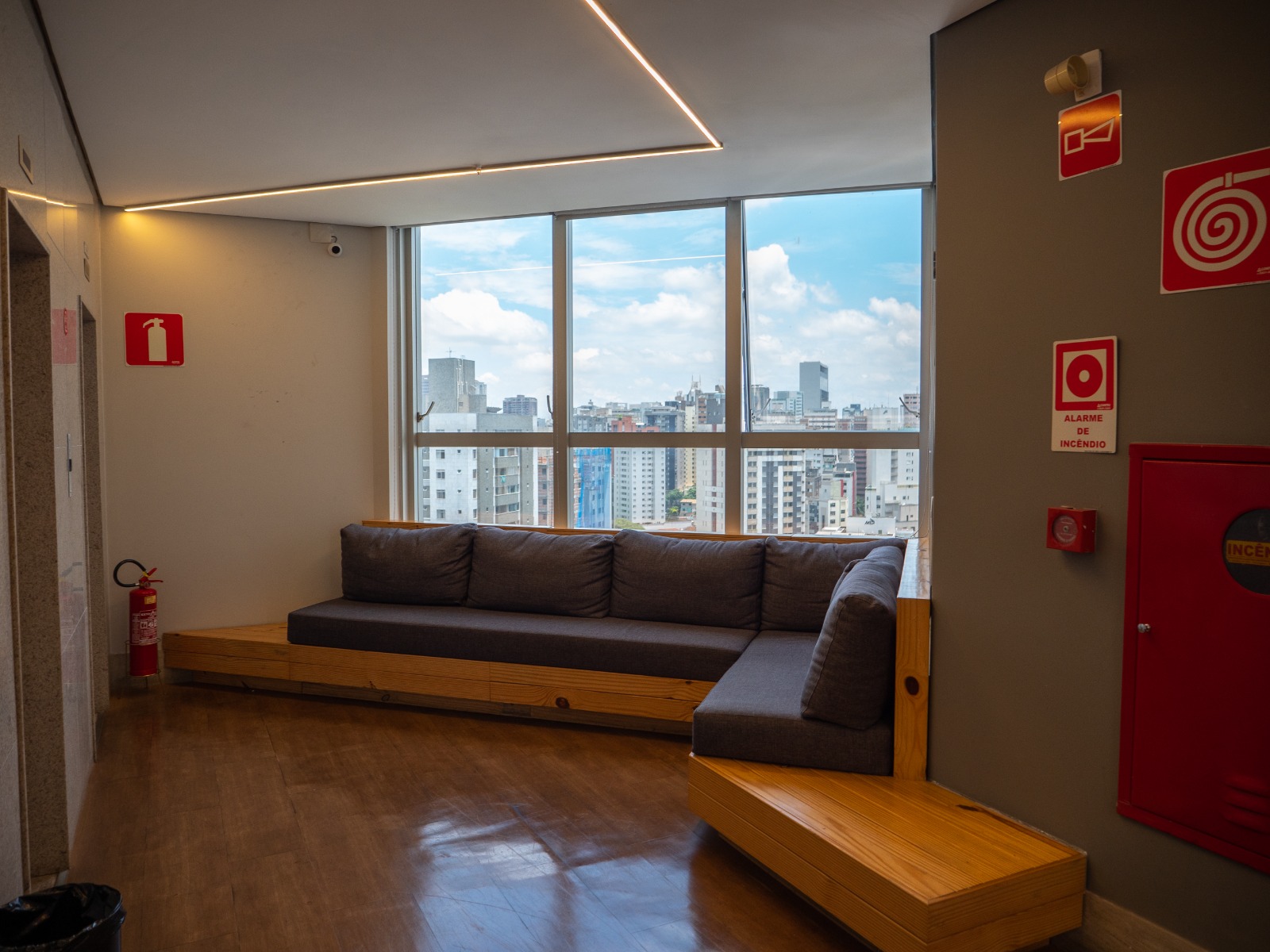 Lounge com sofá e janela panorâmica com vista para Belo Horizonte